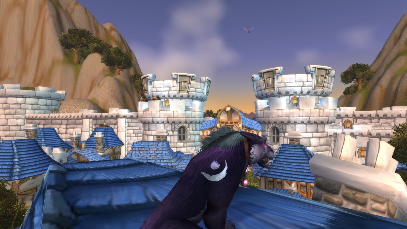 A dark gryphon marked with a white crescent stands on blue rooftops between bright stone towers at sunset.